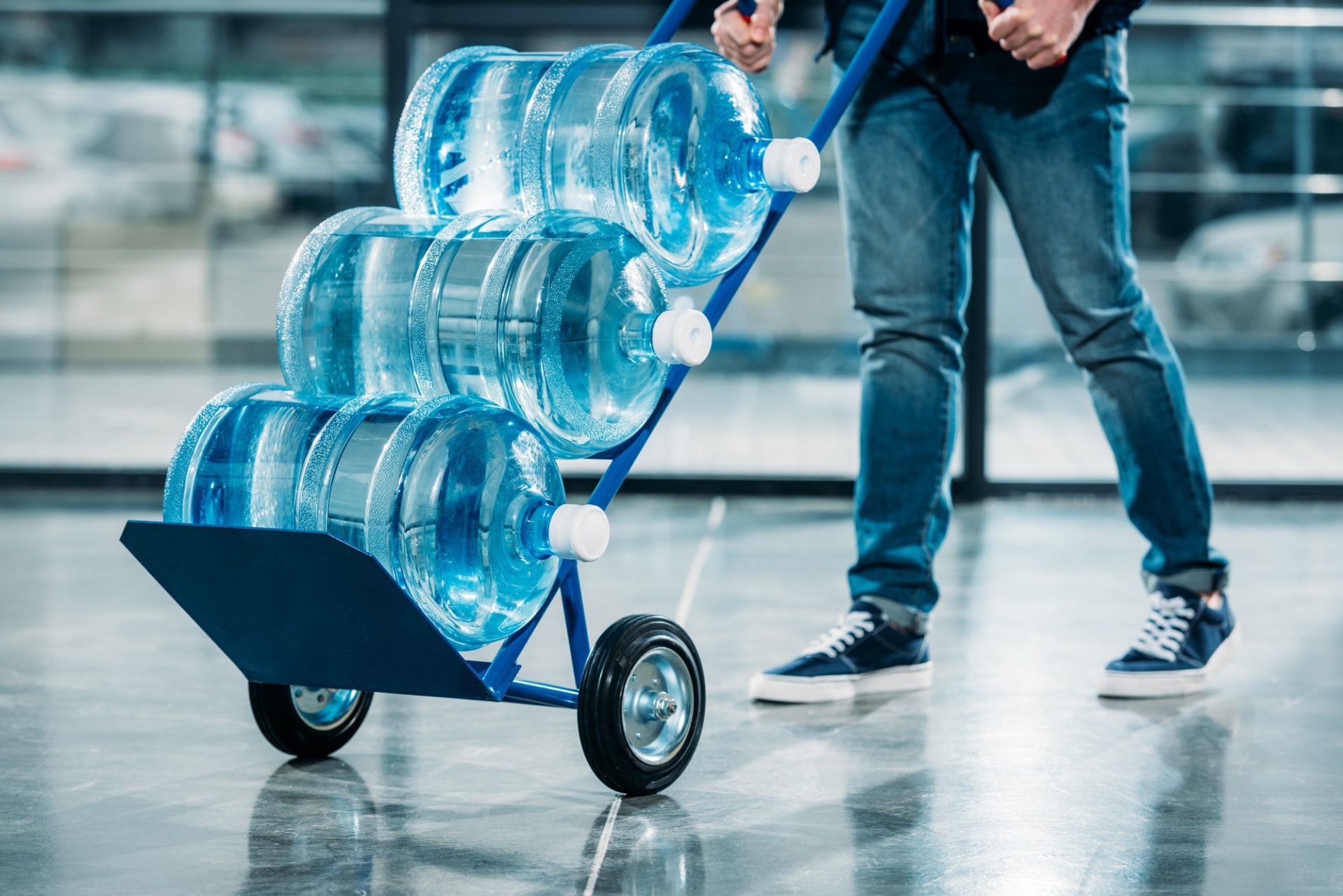loader-pushing-cart-with-water-bottles-e1635171694390